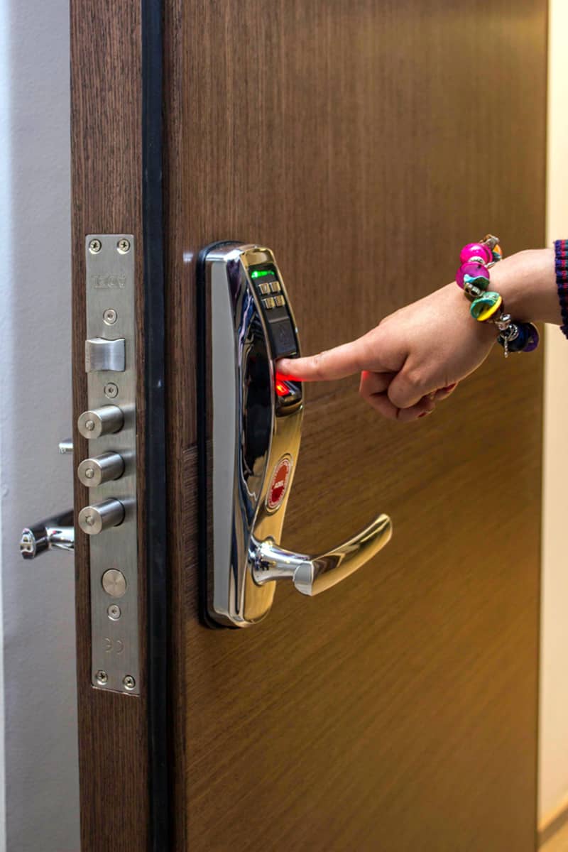 Woman's hand operating smart lock on door