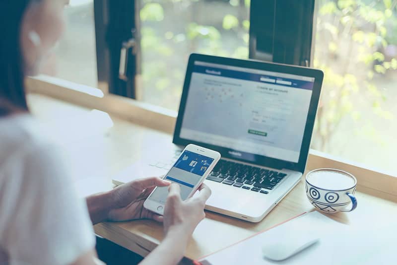 Woman using Facebook in cafe